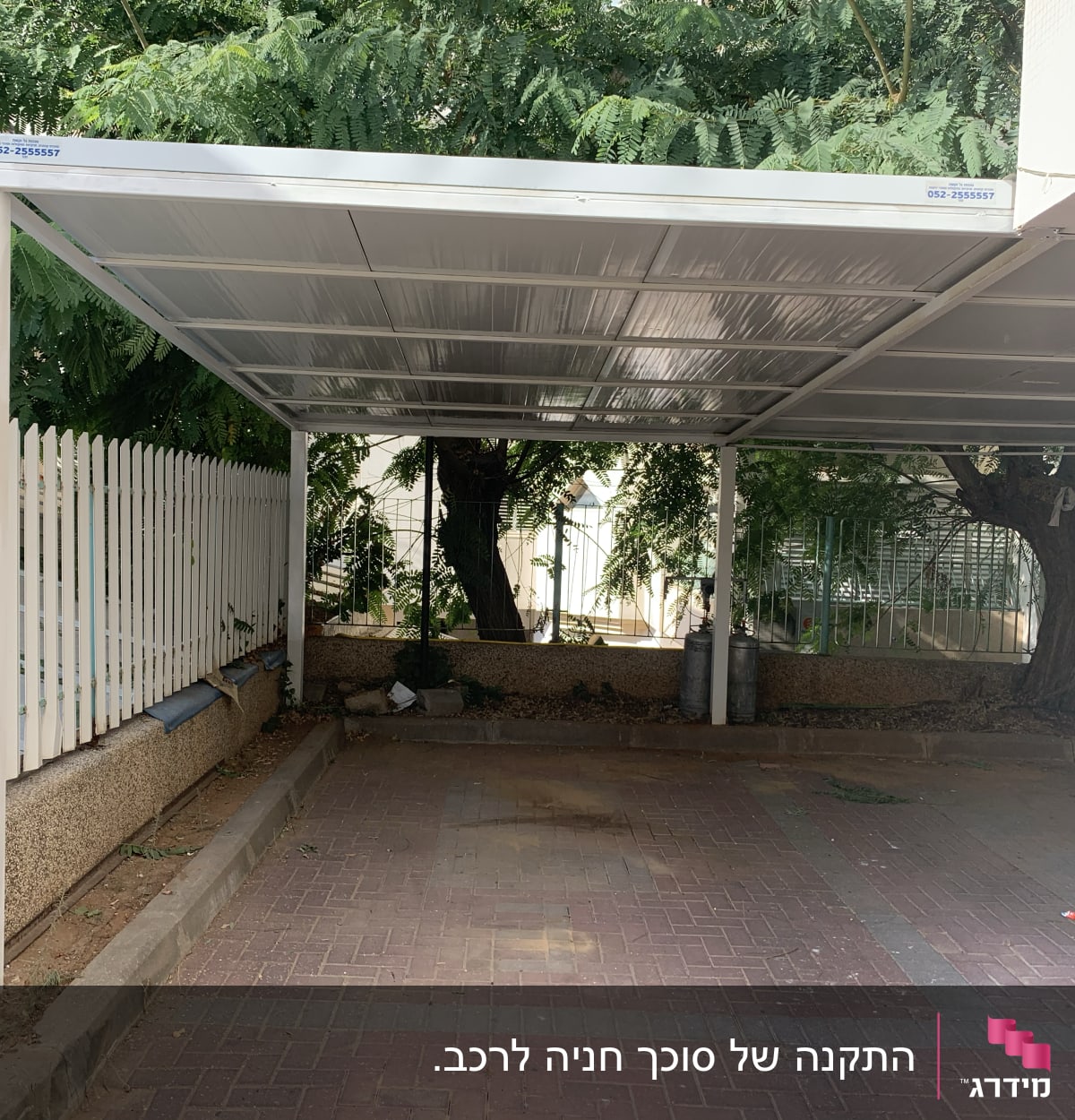 סככה לבנה עם עמודי תמיכה מתכתיים